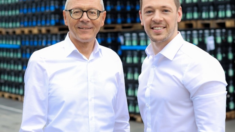 Die Geschäftsführer der Stiftsquelle, Michael und Sebastian Brodmann, vor ihrem Lager mit Wasserkästen.