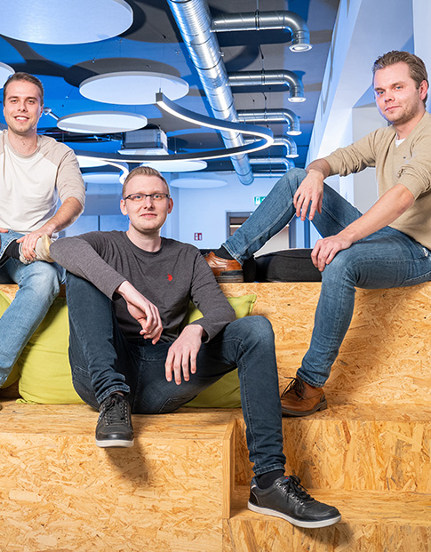 Die drei Gründer der App Tremaze sitzen auf einem Podest.