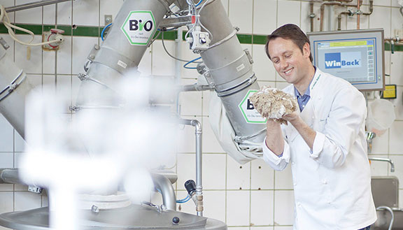 Das Bild zeigt Bäcker Roland Schüren. Er begutachtet einen Teig. Mit Investitionen hat er den Energieverbrauch für die Produktion gesenkt.