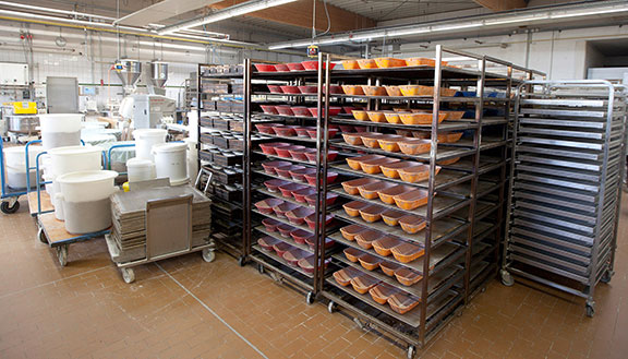 Das Bild zeigt die Backstube der Bäckerei Schüren. Es sind viele Regale und Teigformen zu sehen. Mithilfe der NRW.BANK hat er Energie eingespart.