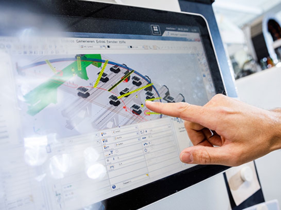 Eine Hand deutet auf einen Bildschirm, auf dem ein Plan einer technischen Anlage zu sehen ist.