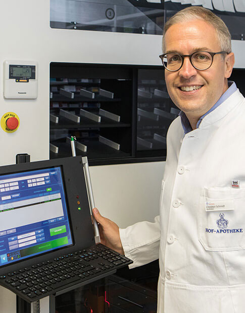 Apotheker Christian Schmidt vor seiner automatischen Rollschrankanlage mit integriertem Laptop