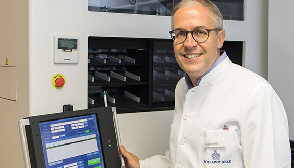Apotheker Christian Schmidt vor seiner automatischen Rollschrankanlage mit integriertem Laptop