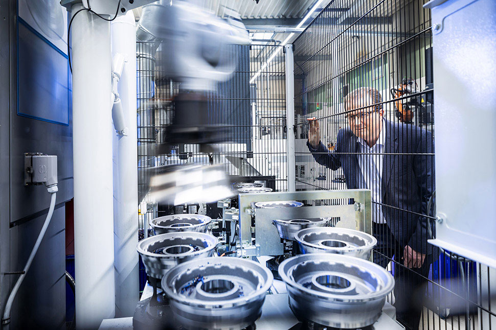 Jürgen Bischopink vom Automobilzulieferer Fischer und Kaufmann betrachtet durch einen Zaun die Produktion von Metallbauteilen.