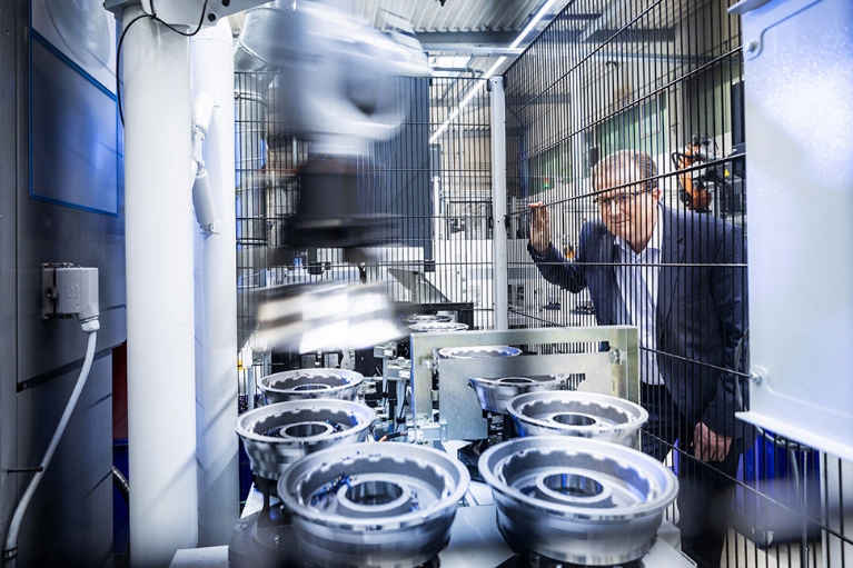 Jürgen Bischopink vom Automobilzulieferer Fischer und Kaufmann betrachtet durch einen Zaun die Produktion von Metallbauteilen.