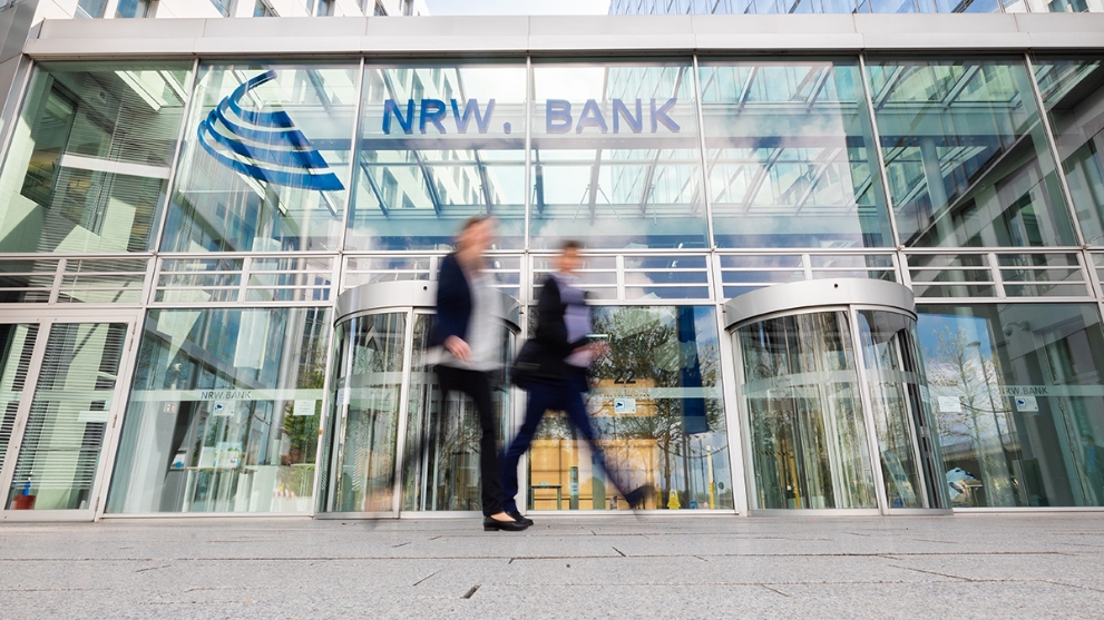 Zwei Menschen vor dem gläsernen Eingangsbereich der NRW.BANK-Zentrale in Düsseldorf