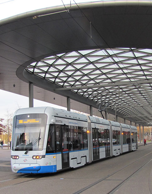 Weiße Straßenbahn der BOGESTRA unter dem modernen Dach einer Haltestelle