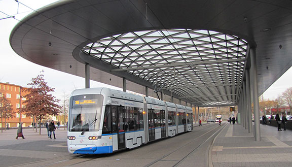 Weiße Straßenbahn der BOGESTRA unter dem modernen Dach einer Haltestelle