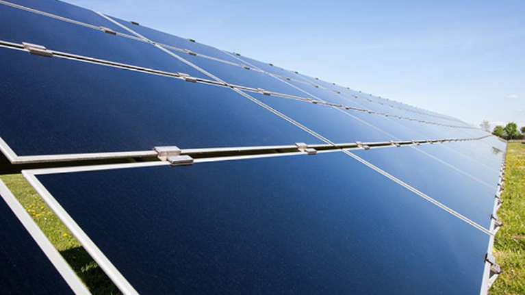 Nahaufnahme einer großflächigen Solaranlage, die in Richtung Sonne geneigt ist