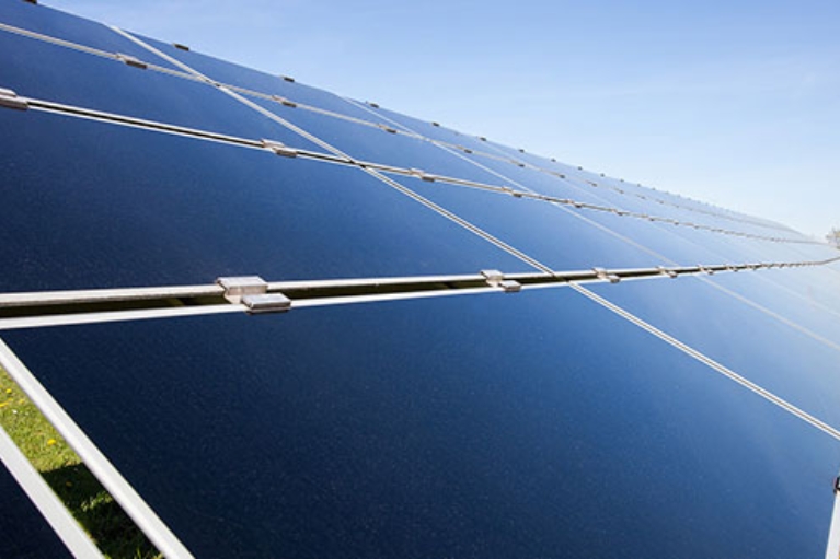 Nahaufnahme einer großflächigen Solaranlage, die in Richtung Sonne geneigt ist