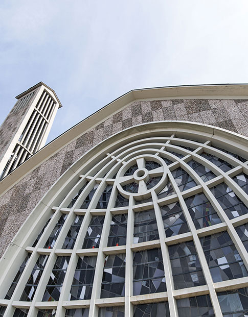 Graue Steinfassade der Martinskirche in Beckum mit kunstvoll geschwungenen Fenstern