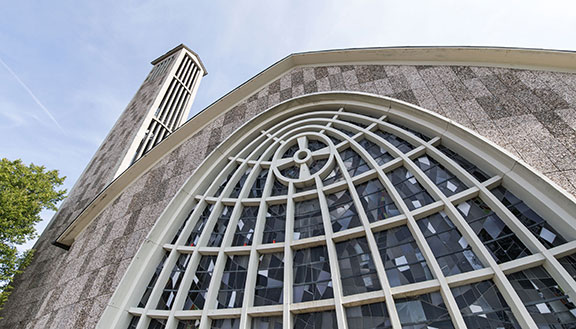Graue Steinfassade der Martinskirche in Beckum mit kunstvoll geschwungenen Fenstern