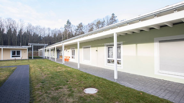 Einstöckiges Gebäude des Seniorenzentrum Süssendell, davor eine Wiese und ein Fußweg