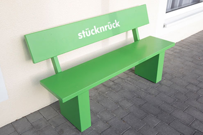 Grüne Holzbank mit der Aufschrift Stücknrück