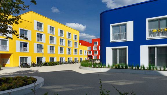 Gebäude einer Passivhaussiedlung für Studierende mit leuchtend gelb-rot-blauer Fassade