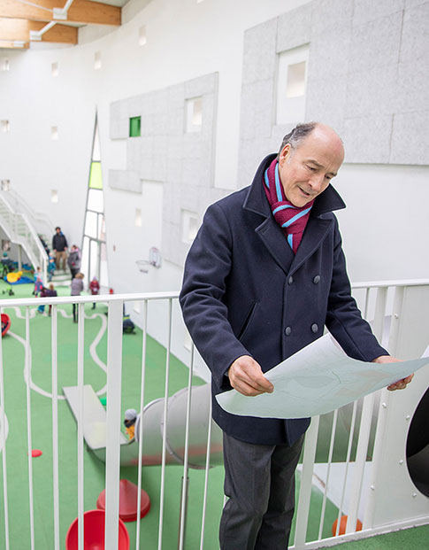 Dr. Christian Jaeger, Geschäftsführer der Wohn + Stadtbau Münster, in der Kindertagesstätte. Im Hintergrund spielende Kinder.