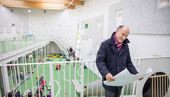 Dr. Christian Jaeger, Geschäftsführer der Wohn + Stadtbau Münster, in der Kindertagesstätte. Im Hintergrund spielende Kinder.