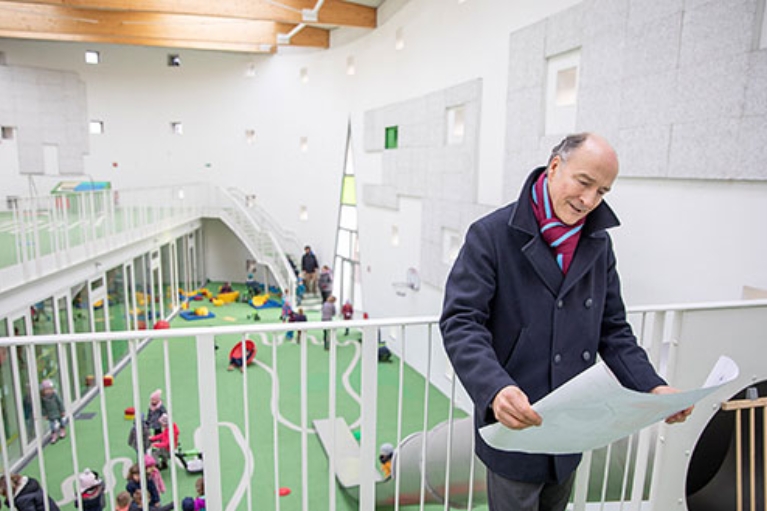 Dr. Christian Jaeger, Geschäftsführer der Wohn + Stadtbau Münster, in der Kindertagesstätte. Im Hintergrund spielende Kinder.