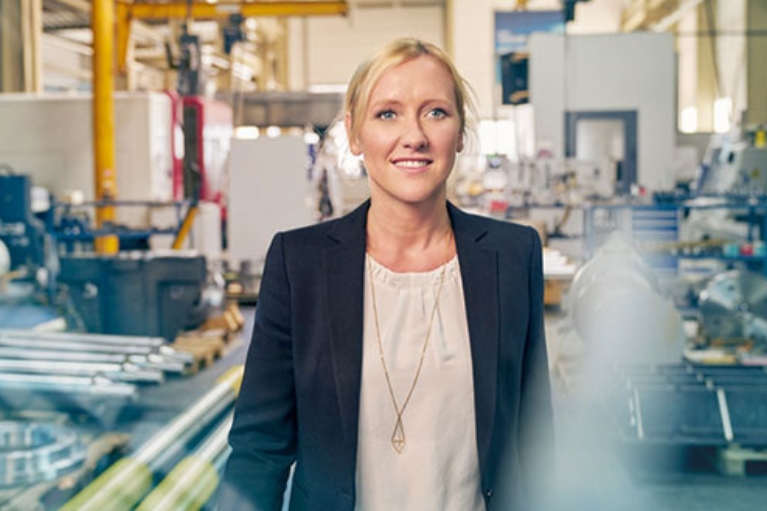 Unternehmerin Melanie Baum groß von vorne in der Werkshalle ihres Unternehmens