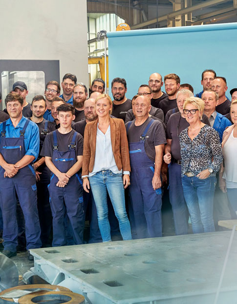Gruppenbild der Belegschaft der Firma Baum Zerspanungstechnik in einer Werkshalle, rund 35 Personen