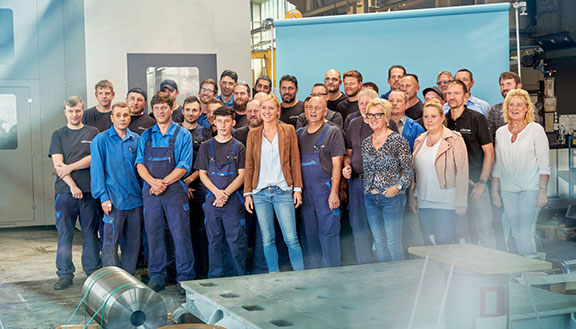 Gruppenbild der Belegschaft der Firma Baum Zerspanungstechnik in einer Werkshalle, rund 35 Personen