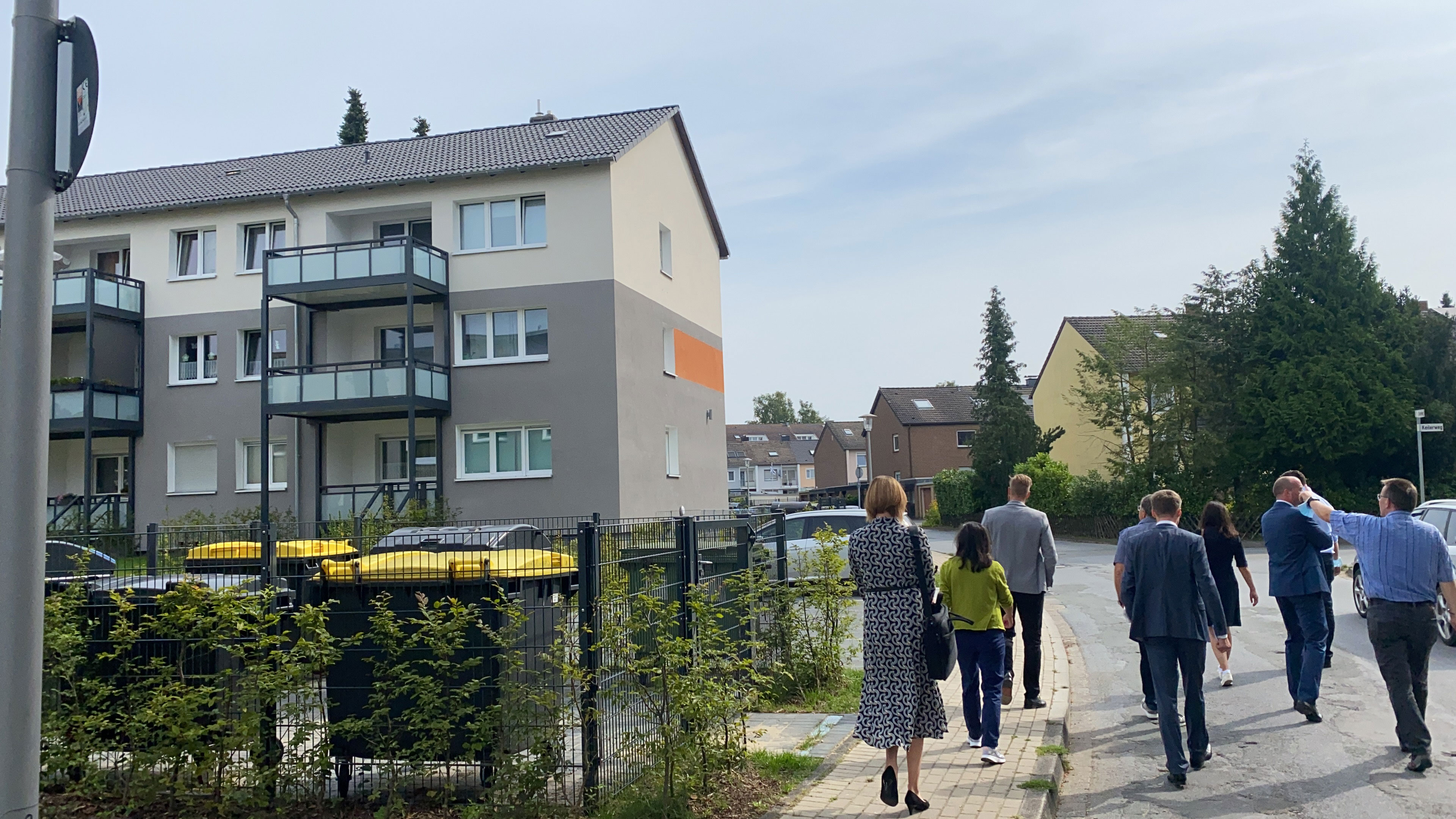 Eine Gruppe von Menschen beim Spaziergang durch ein Wohnviertel
