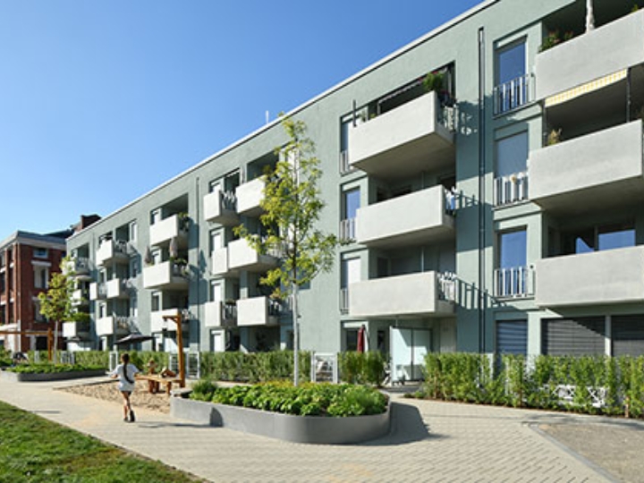 Hausfassade des neuen Clouth Quartiers mit Balkonen und einem Spielplatz