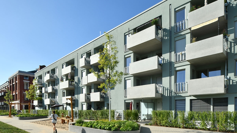 Hausfassade des neuen Clouth Quartiers mit Balkonen und einem Spielplatz