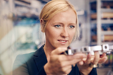 Unternehmerin Melanie Baum betrachtet ein produziertes Bauteil.