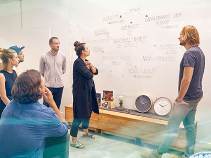 Mehrere Mitarbeiter von Kerbholz in einer Besprechung vor einem Whiteboard mit Notizen