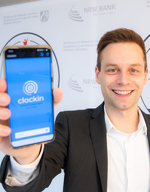 Mitgründer Frederik Neuhaus von clockin präsentiert die App des Unternehmens.