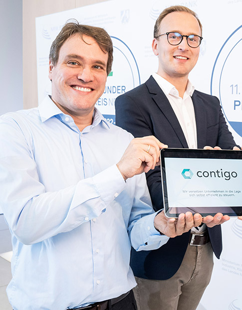 Die Nominierten des Gründerpreises 2022 Sebastian Jansen und Nicolas Stamer der Contigo Consulting AG halten ein Tablet-Computer in den Händen mit ihrem Firmenlogo.