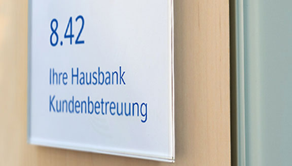 Büro-Türschild mit der Aufschrift: Ihre Hausbank Kundenbetreuung