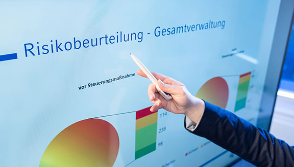 Das Bild zeigt einen großen Bildschirm mit Diagrammen zur Risikobeurteilung. Die NRW.BANK unterstützte die Stadt Lünen beim Risikomanagement.