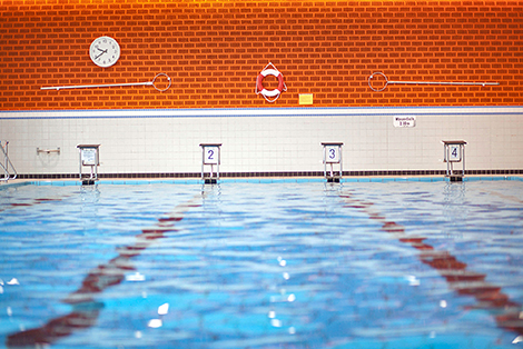 Ein Schwimmbecken mit Blick auf vier Startblöcke