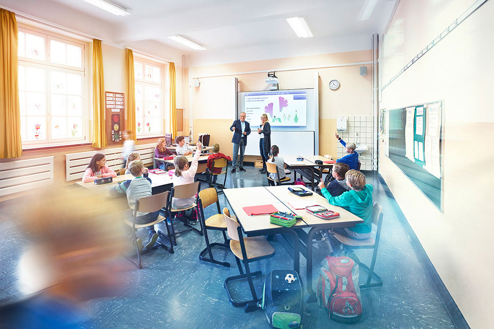 Eine Schulklasse mit einem smarten Whiteboard im Hintergrund
