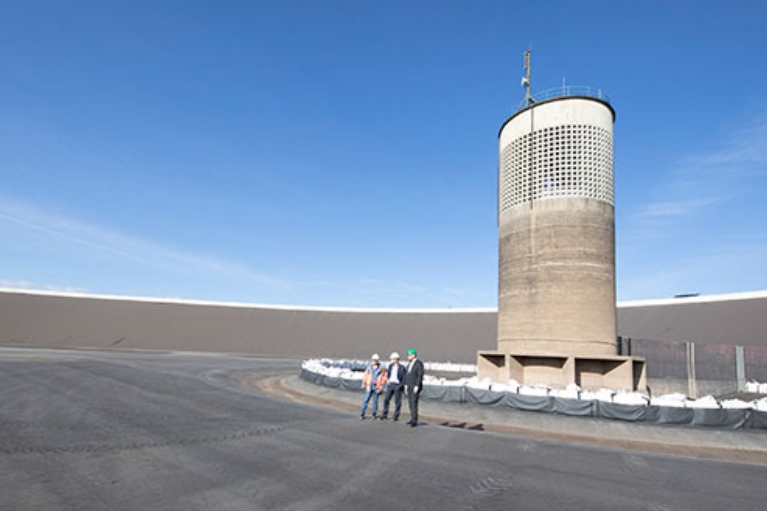 Drei Männer stehen im Außenbereich des Pumpspeicherwerks Rönkhausen.