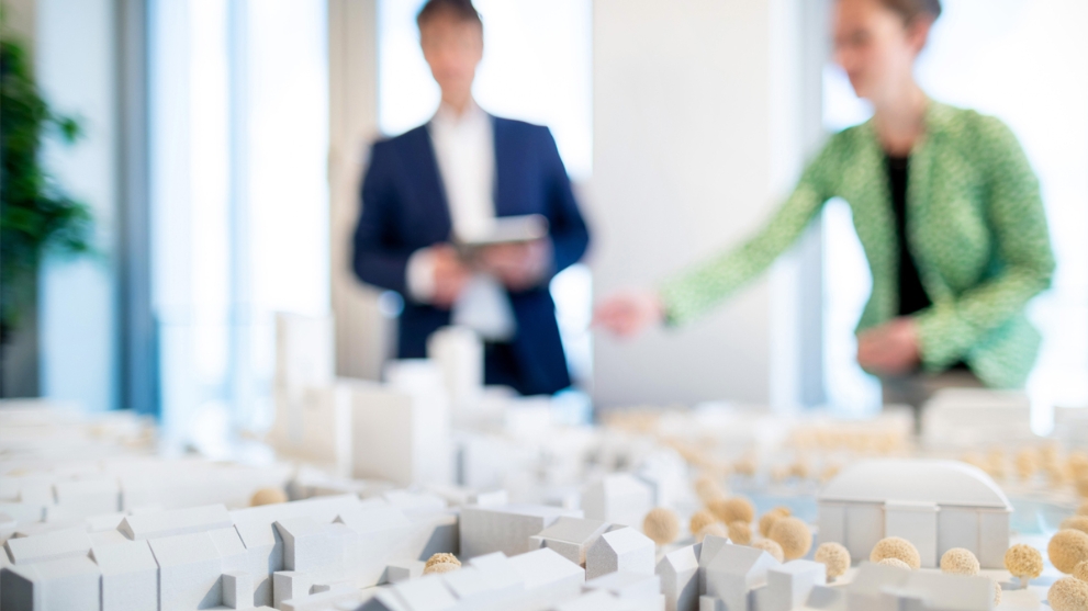 Ein Mann und eine Frau betrachten eine Modellstadt