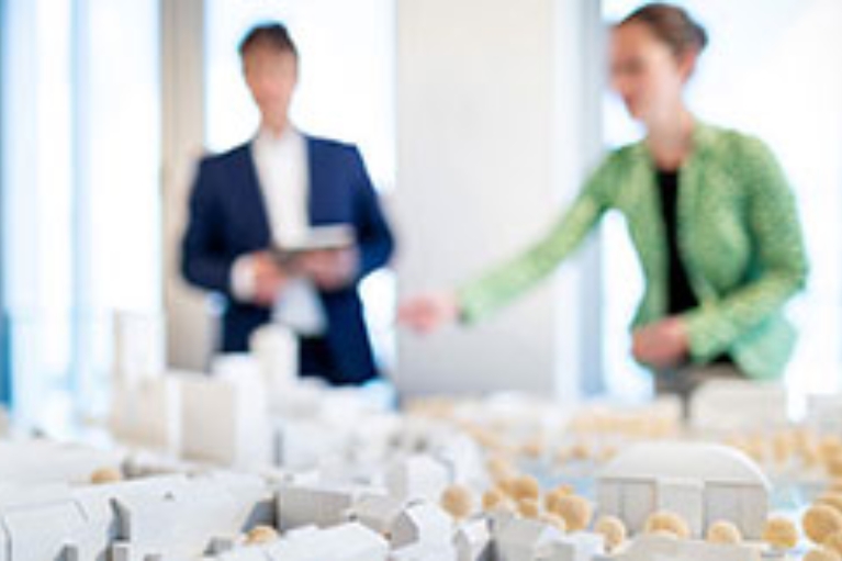 Ein Mann und eine Frau betrachten eine Modellstadt