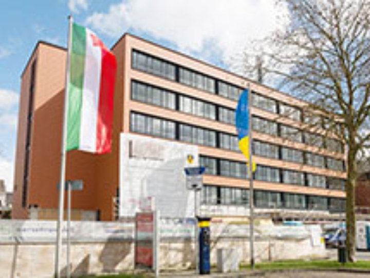 Ein kommunales Gebäude, an dem Baumaßnahmen durchgeführt werden, mit der NRW-Fahne im Vordergrund