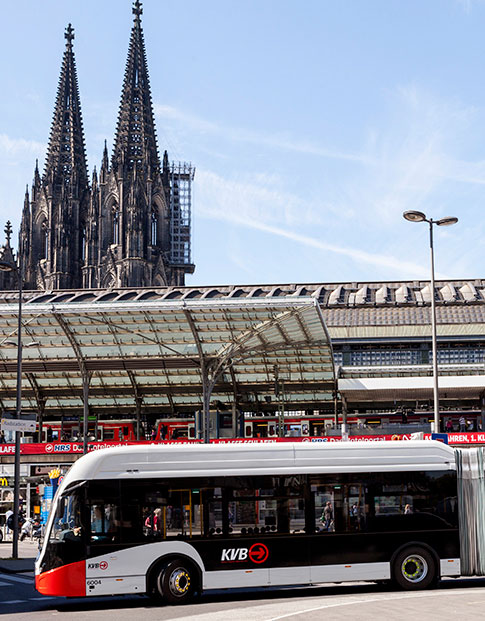 : Von der NRW.BANK geförderter E-Bus der Kölner Verkehrsbetriebe (KVB) vor dem Kölner Hauptbahnhof und dem Kölner Dom.