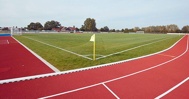 Fußballplatz mit roter Laufbahn außen herum