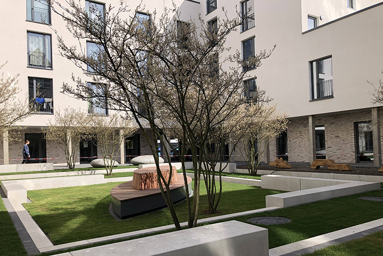 Idyllischer Innenhof eines Studierendenwohnheims mit Sitzgelegenheiten und Pflanzen