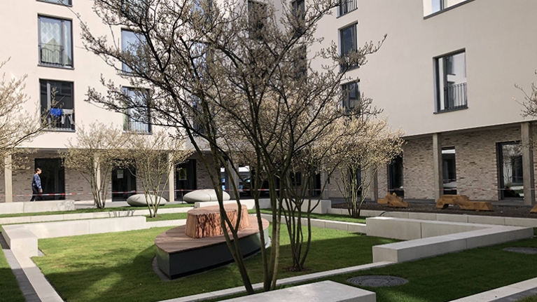 Idyllischer Innenhof eines Studierendenwohnheims mit Sitzgelegenheiten und Pflanzen