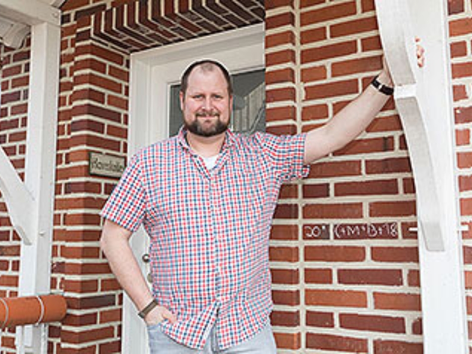 Sebastian Haverkotte steht vor dem Eingangsbereich seines Hauses mit roter Backsteinfassade