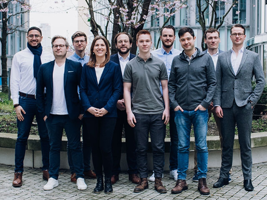 Das Team von Taxy.io: Gruppenfoto mit 10 Mitarbeitern vor dem Bürogebäude