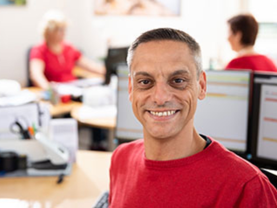 Sascha Jung von der Pflegebetriebe Jung GmbH im Büro, im Hintergrund 2 Mitarbeiterinnen