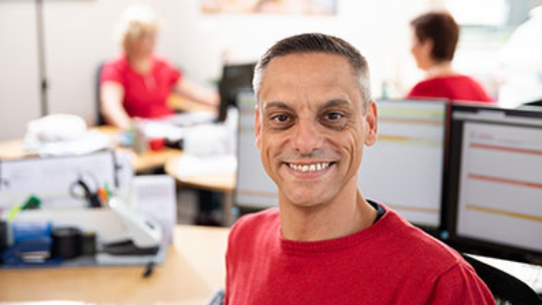 Sascha Jung von der Pflegebetriebe Jung GmbH im Büro, im Hintergrund 2 Mitarbeiterinnen