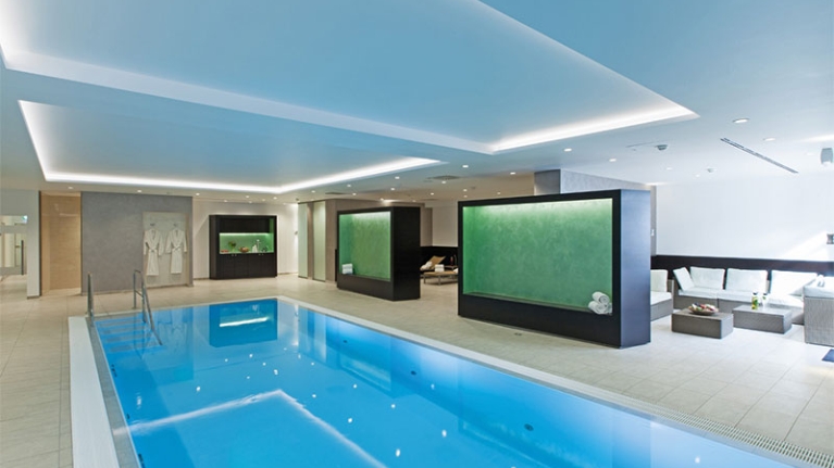 Moderne, helle Pool-Landschaft mit Schwimmbecken und Sitzecke