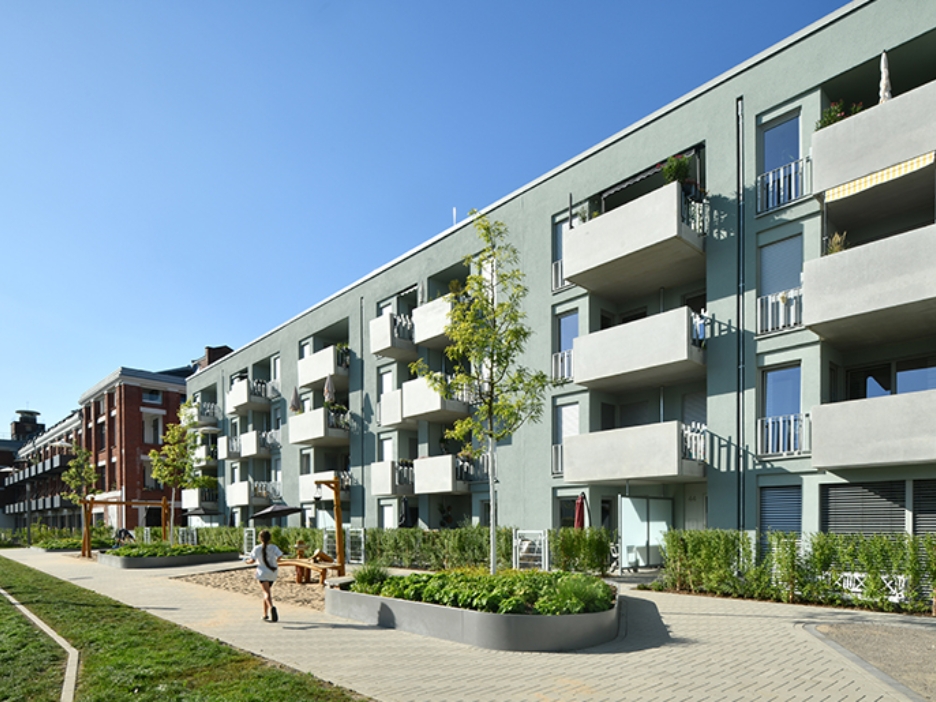 Hausfassade des neuen Clouth Quartiers mit Balkonen und einem Spielplatz
